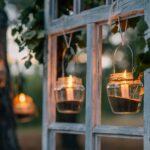 Blick auf einen Garten mit Kerzen im Glas