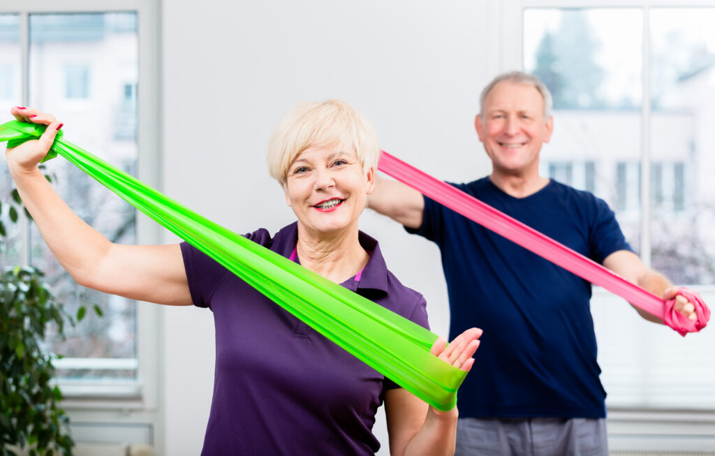 Senioren trainieren mit bunten Fitnessbändern | Rechteckpool
